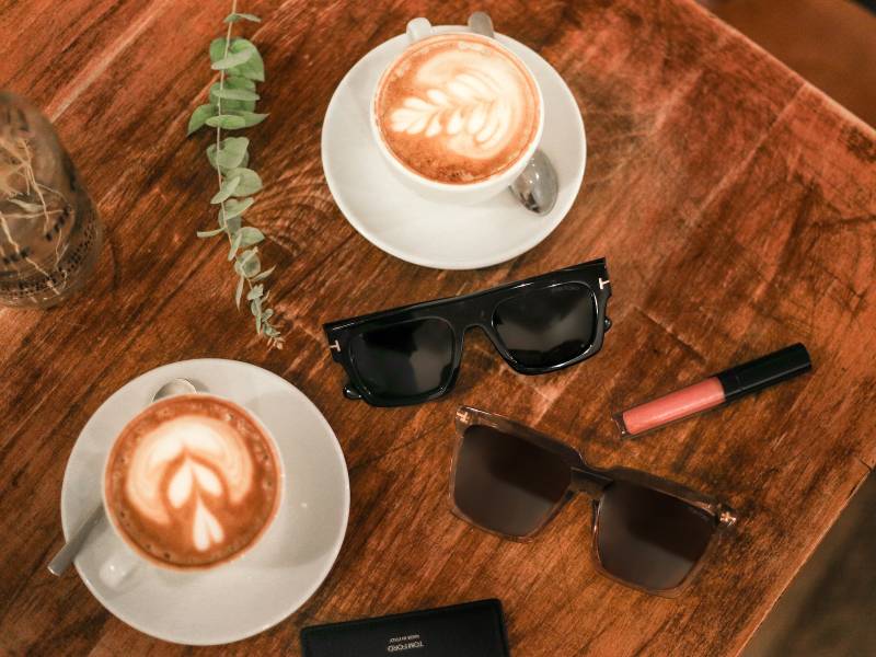 Balise ALT : Une cliente épanouie dévoile son nouveau look avec des lunettes de soleil Tom Ford, devant la boutique Atol Bordeaux Lac. Style, élégance et confort garantis